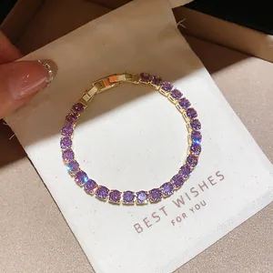 Close-up of elegant gold tennis bracelet featuring sparkling round purple zircons
