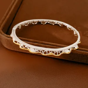 Primo piano di un bracciale rigido a pizzo vintage con accenti dorati e strass brillanti