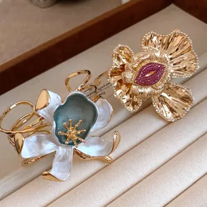 Detailed view of vintage gold pleated flower bangle with blue enamel and red crystals