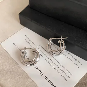 Detailed view of the intricate double-layer cross design on these silver hoop earrings