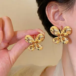 Elegant golden hammered butterfly C-shaped stud earrings with a rich metallic texture finish
