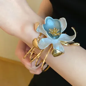 Detailed view of luxury vintage flower open bangle with blue enamel and golden wavy strands