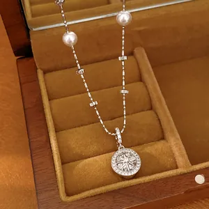 Detail view of silver-toned necklace featuring cubic zirconia eight-pointed star pendant and pearls