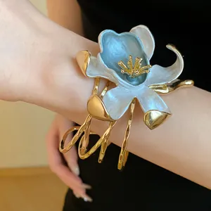 Close-up of an elegant vintage enamel flower cuff bracelet worn on a model wrist