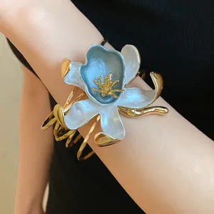 Close-up view of a luxury vintage blue and white pleated flower cuff bracelet on wrist