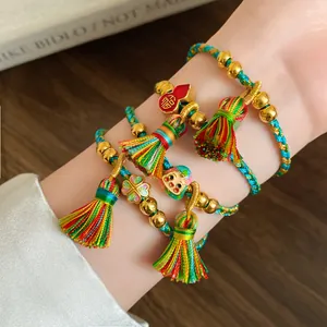 Close-up view of handmade woven colorful rope bracelets with golden beads and festive charms.