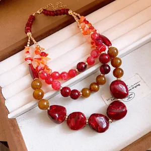 Detail of multi-layer agate and resin beaded necklace in warm red and amber tones