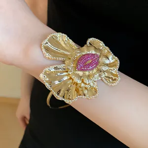 Detailed view of a vintage-style gold flower cuff bracelet with pink rhinestone center