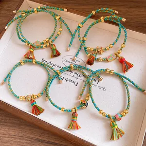 Detailed macro shot of hand-woven colorful rope bracelets featuring enamel charms and tassels
