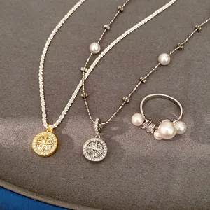 Close-up of zircon eight-pointed star pendant necklaces and elegant pearl ring on grey mat