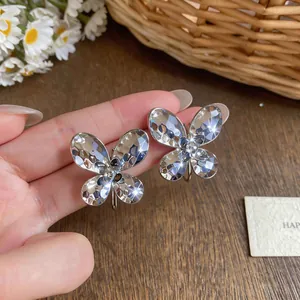Macro view of sparkling silver butterfly-shaped earrings with a crinkled metal finish
