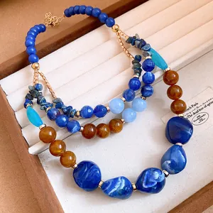 Detailed view of multi-layered beaded necklace with blue and amber resin stones