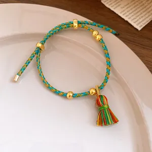 Close-up of handwoven five-color cord bracelet with vibrant tassel detail.