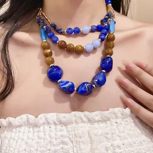 Detailed view of bohemian multilayer necklace with blue resin beads and stones.