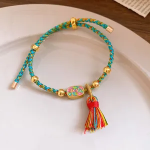Close-up of a handmade braided multi-colored bracelet with 'Ping An' charm and tassel.