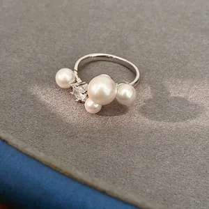 Detailed macro view of a silver ring adorned with white pearls and sparkling zircon