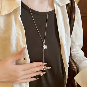 Elegant adjustable Y-necklace with white shell flower pendant on a female model