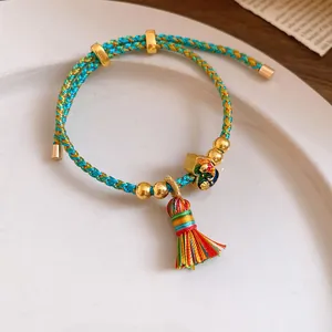 Close-up of handmade braided five-color rope bracelet with colorful tassel detail