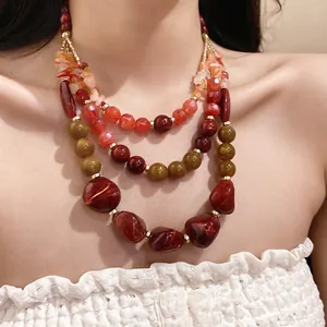 Detailed close-up shot of multi-layered agate and resin bead necklace on female model