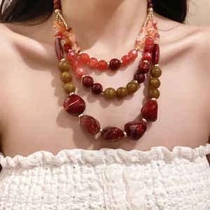 Detailed macro view of an elegant multi-layer resin and agate beaded necklace on a model