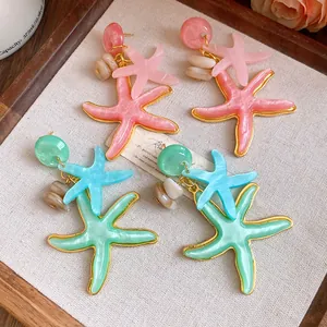 Detail of vacation style resin starfish earrings in pink and mint green finishes