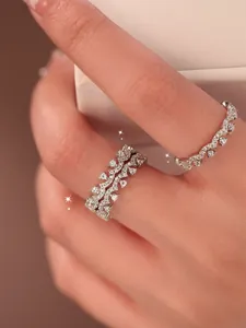 Detailed close-up of elegant sparkly zircon lace rings stacked on fingers for women