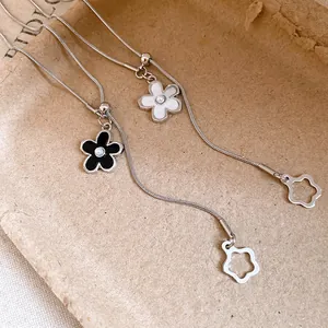 Macro detail showing adjustable snake chain necklaces with elegant enamel flower pendants