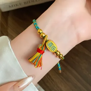 Detailed view of a handmade woven five-colored rope bracelet with gold beads and tassel