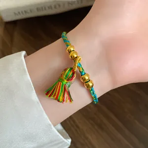 Close-up of handmade Dragon Boat Festival colorful woven bracelet with gold beads and tassel
