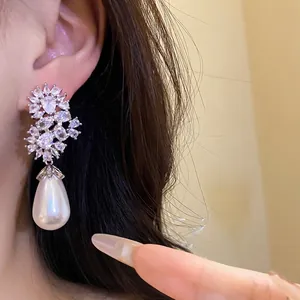 Pendientes de plata elegantes con circonitas brillantes y perla en forma de gota.