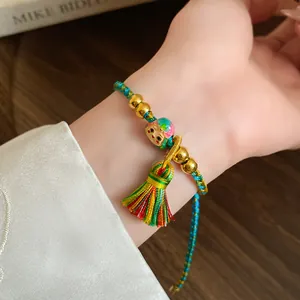Detailed view of handmade woven colorful cord bracelet with tassel and beads