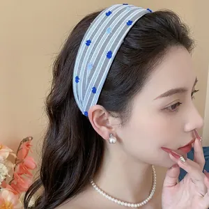 Cerchietto in tessuto a righe stile coreano con motivi floreali blu su una modella