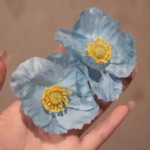 Gros plan détaillé de boucles d'oreilles élégantes en tissu bleu avec étamines jaunes