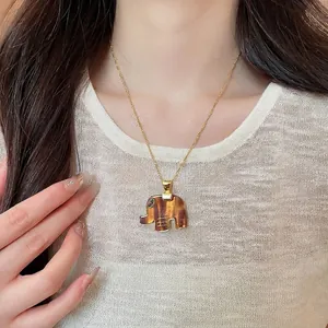 Elegant resin elephant pendant necklace with gold chain worn by a female model