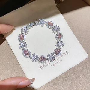 Detailed macro view of sparkling pink and white flower zircon bracelet in gift pouch