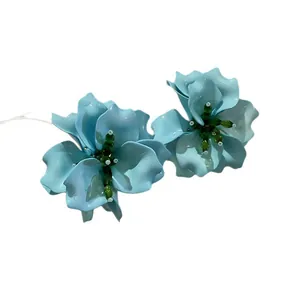 Boucles d'oreilles fleurs bleu clair avec pistils en perles vertes pour un look chic