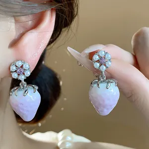 Close-up detail of sweet resin strawberry stud earrings with pink zircon and pearls detail