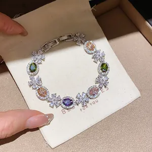 Detailed view of luxury colorful zircon flower bracelet on elegant white fabric pouch