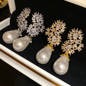 Vista detallada de elegantes pendientes de circonita con grandes perlas en forma de gota