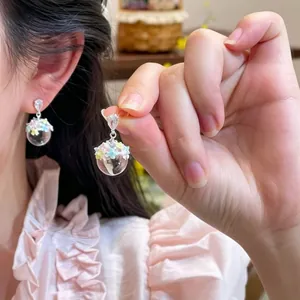 Detailed close-up of sweet ice-transparent earrings featuring colorful oil-dripped flowers