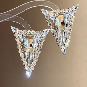 Close-up of glamorous silver needle triangle stud earrings with shimmering rhinestones