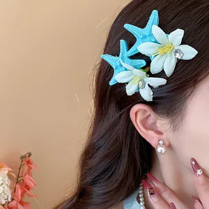 Close-up detail of starfish and flower hair clips on a female model for seaside style