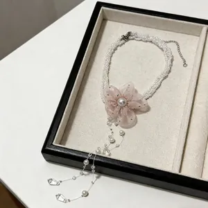 Detail view of pink lace flower pearl necklace with elegant tassel drops in jewelry tray