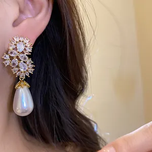 Pendientes de gota elegantes con perla y racimos de circonitas en la oreja