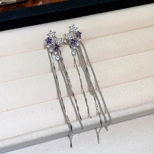 Detailed macro view of silver star tassel clip-on earrings with purple zircon