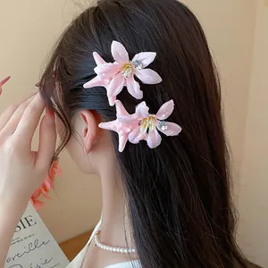 A detailed view of delicate pink starfish and flower hair clips on long brown hair.