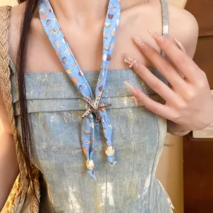 Detailed view of ocean-themed blue silk scarf necklace with a large metal starfish