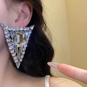 Close-up of large sparkling triangular crystal stud earring for a glamorous look