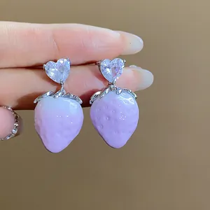 Detail shot of heart-shaped zircon and lavender gradient resin strawberry earrings.