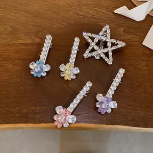 Vue détaillée de barrettes en zircon étincelant avec ours en résine sur table en bois